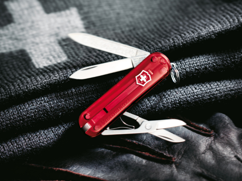 kleines taschenmesser classic rot transparent auf dunkeln nylon hintergrund