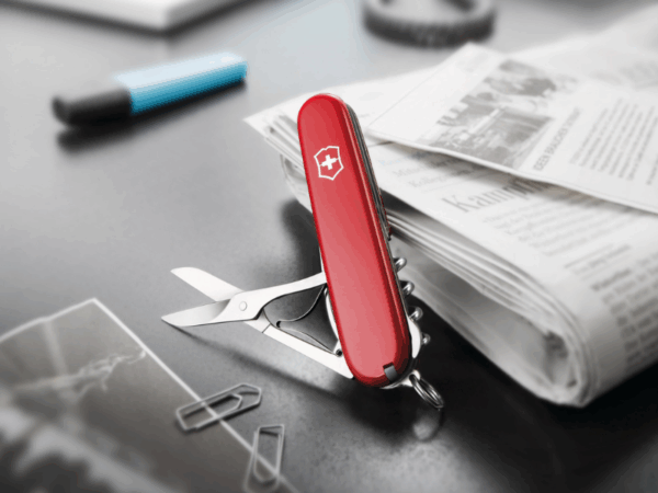 mittleres taschenmesser compact rot auf bürotisch mit zeitung